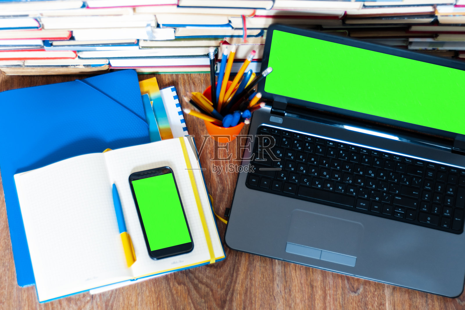 课本、笔记本、绿屏手机、智能手机、绿屏笔记本、叠书。居家办公，远程教育背景，居家理念照片摄影图片