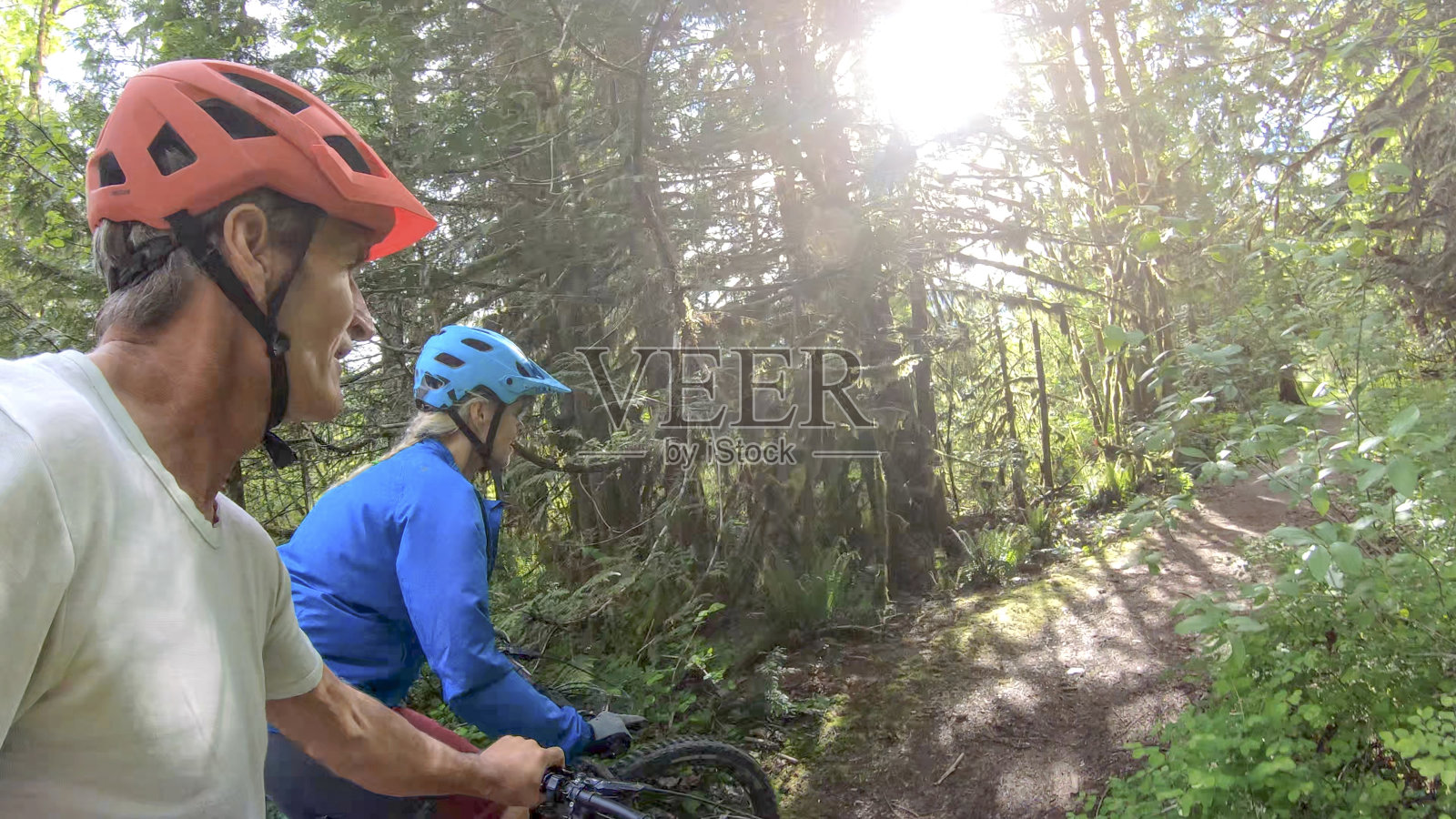 从山地车后面到森林里的第二车手照片摄影图片