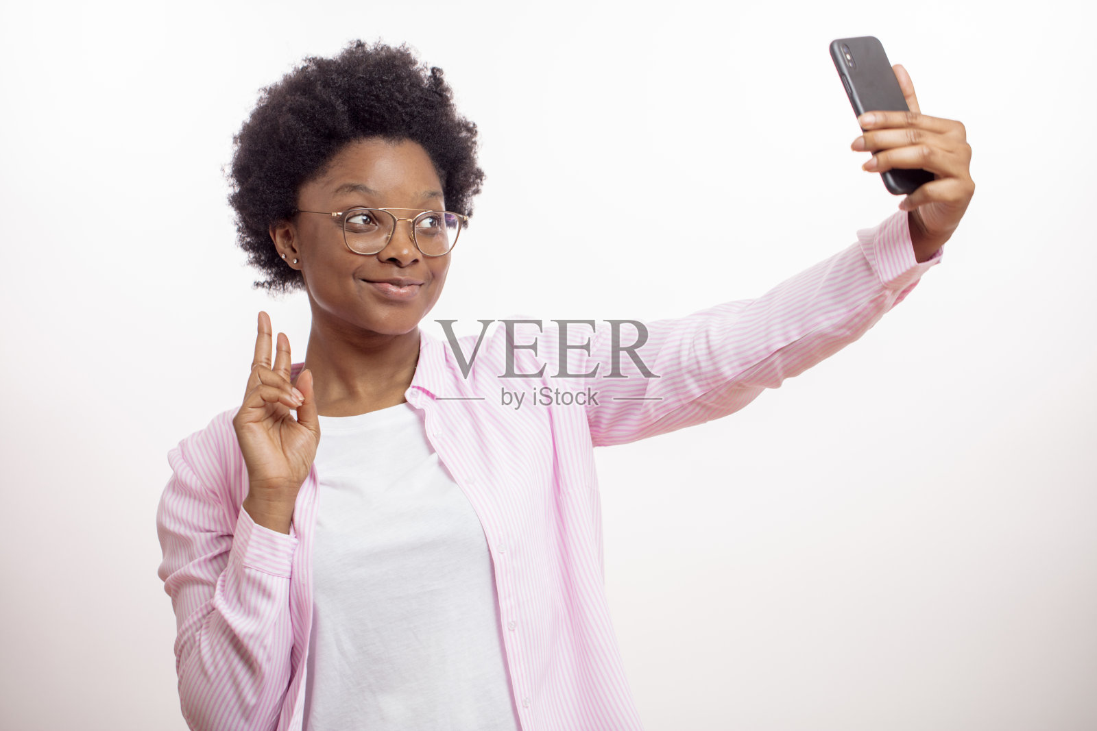 时尚的非洲模特在使用电子设备时伸出两根手指照片摄影图片