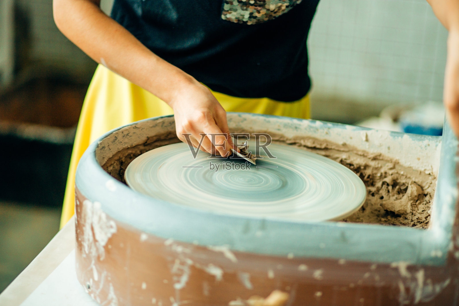 少年陶工的双手，合上瓷杯在陶轮上照片摄影图片
