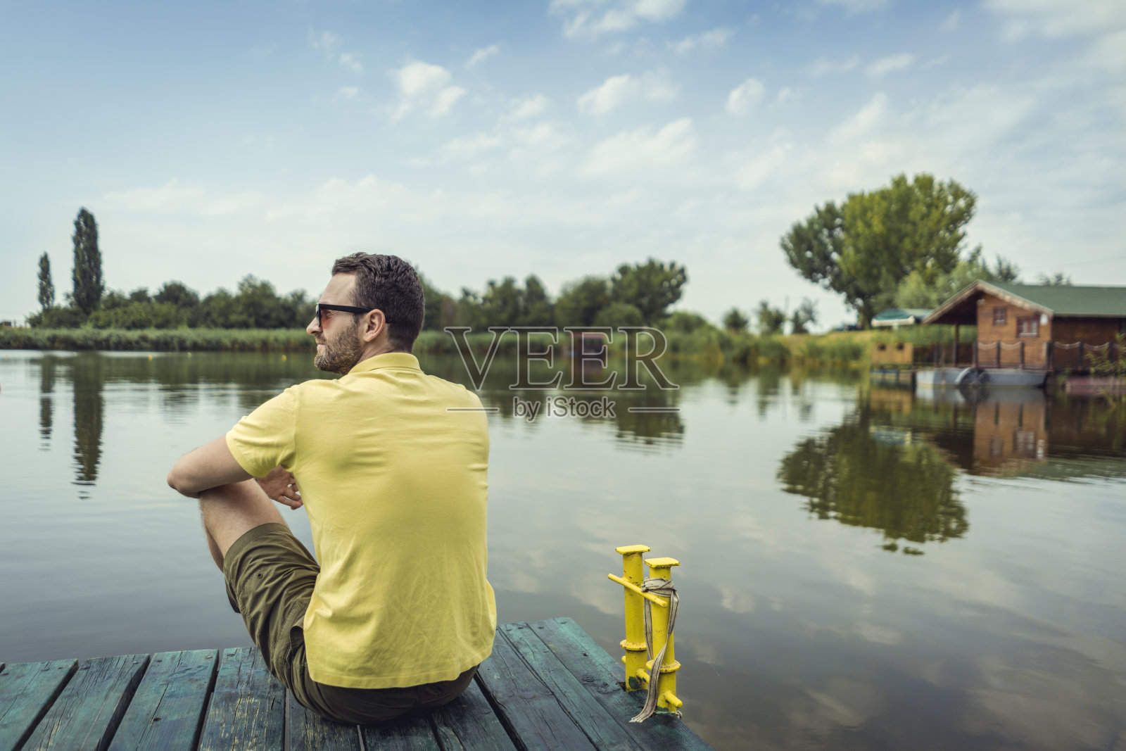 英俊的男子与外面的河边享受夏天照片摄影图片