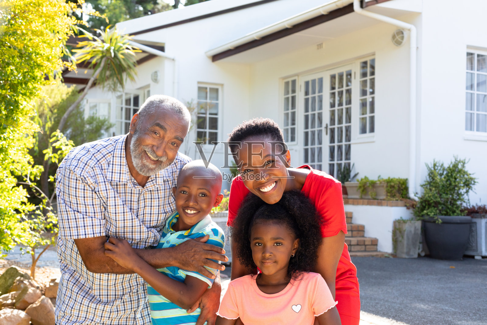 老非裔美国夫妇花时间在他们的孙子和孙女在花园里照片摄影图片