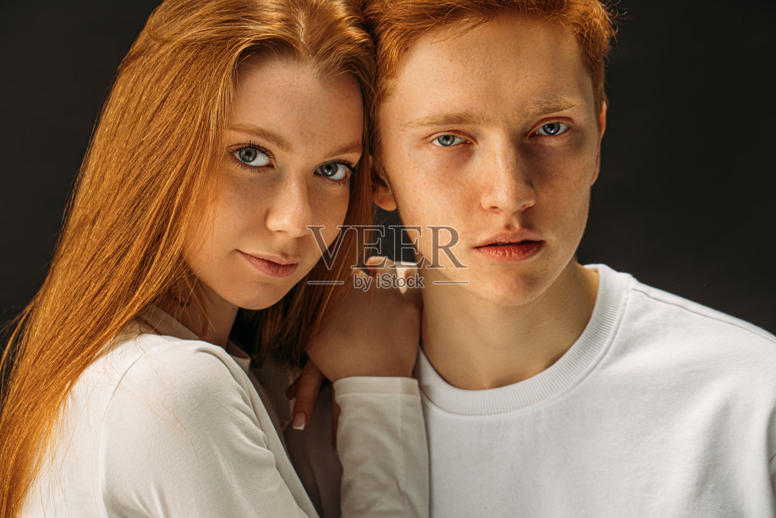 红发男女在摄影棚里一起摆姿势照片摄影图片