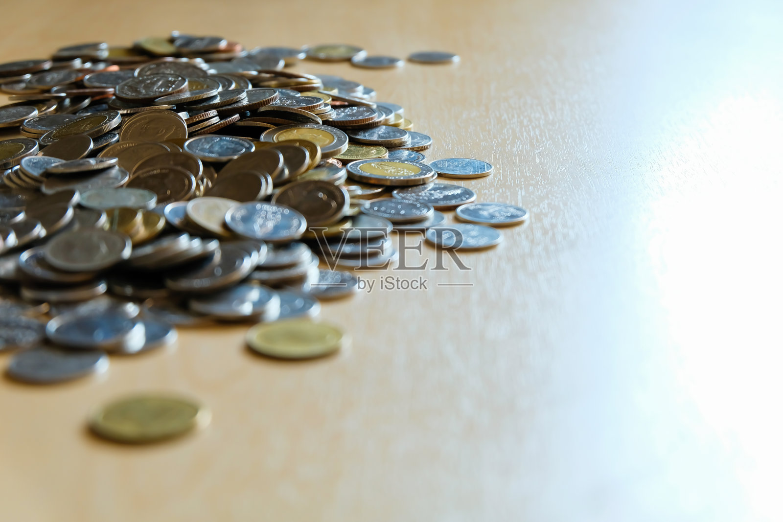 选择性聚焦，将不同类型的泰铢硬币放在浅棕色的木桌上。货币、货币、金融对象，带有文本拷贝空间。理想的储蓄或收入的概念照片摄影图片