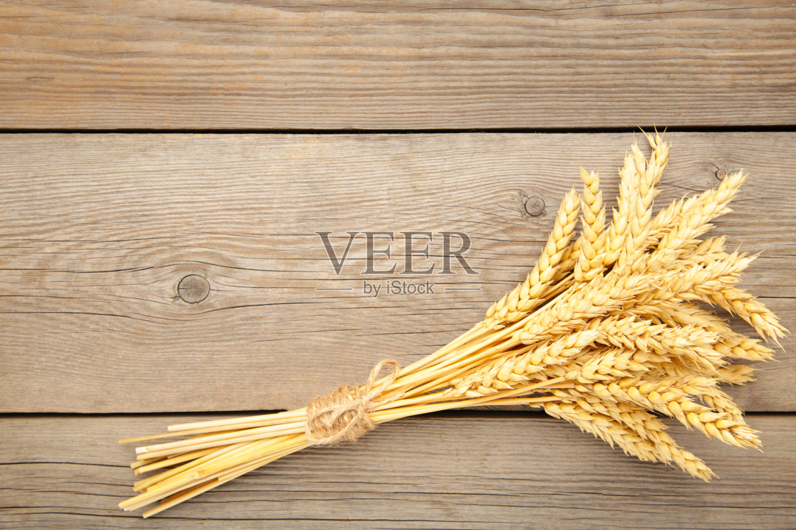 灰色木质背景的小麦束小穗照片摄影图片