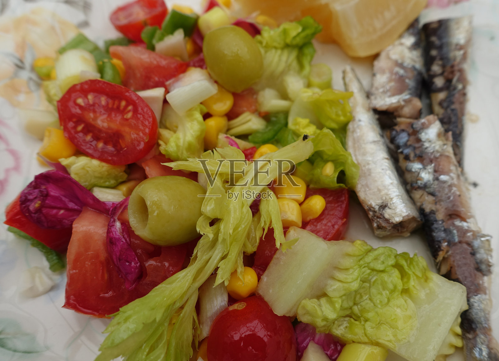 可食用的玫瑰花瓣，西红柿，橄榄，甜玉米，洋葱混合沙拉照片摄影图片