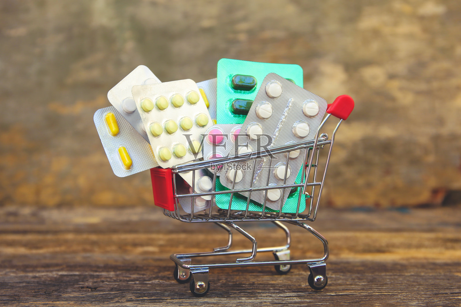 木制背景上的药丸购物车。购买药品的概念。照片摄影图片