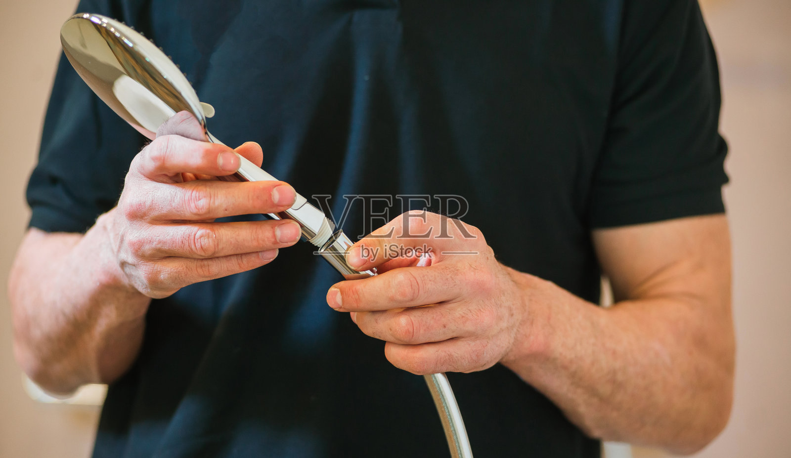 特写一个男人在一个黑暗的t恤在一个淋浴房的水搅拌器照片摄影图片