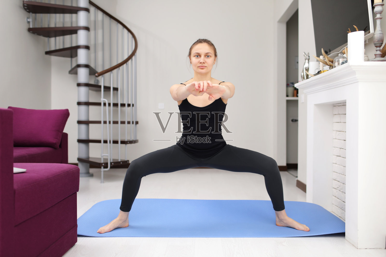 年轻的运动女孩在家里的瑜伽垫上做运动。积极的生活方式。在家健身。度假休闲。身体的平衡。体育锻炼。肱三头肌练习训练。检疫体育照片摄影图片