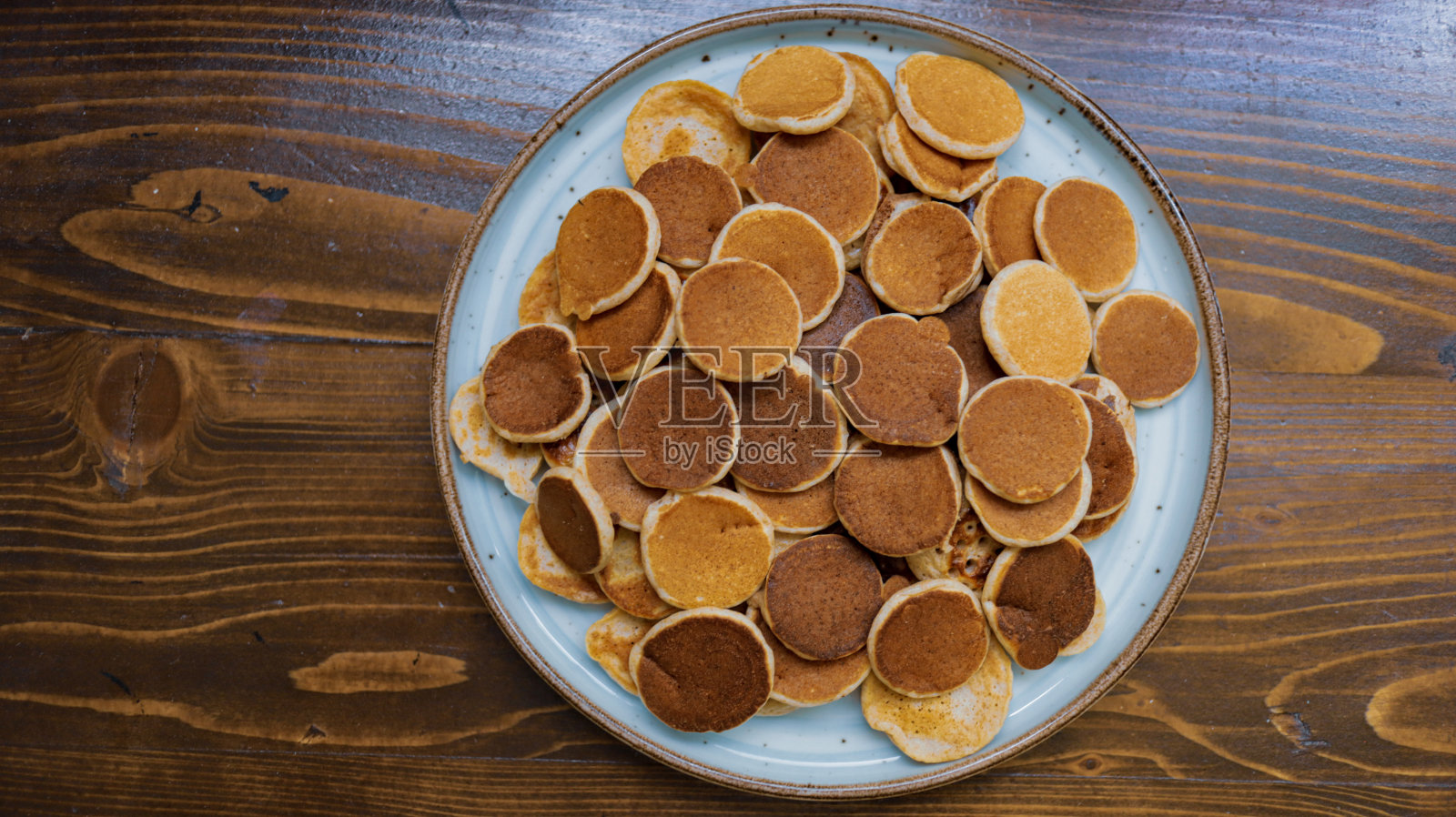 Poffertjes，木制背景的迷你煎饼照片摄影图片