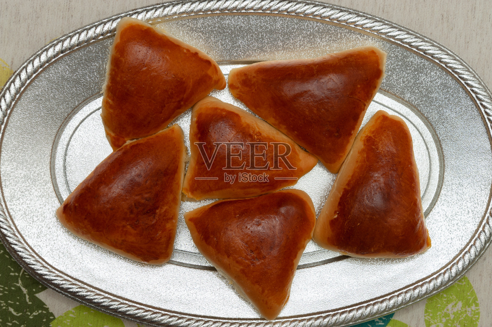 阿拉伯/巴西美食-特写美味的自制esfihas在铝托盘。前视图。照片摄影图片