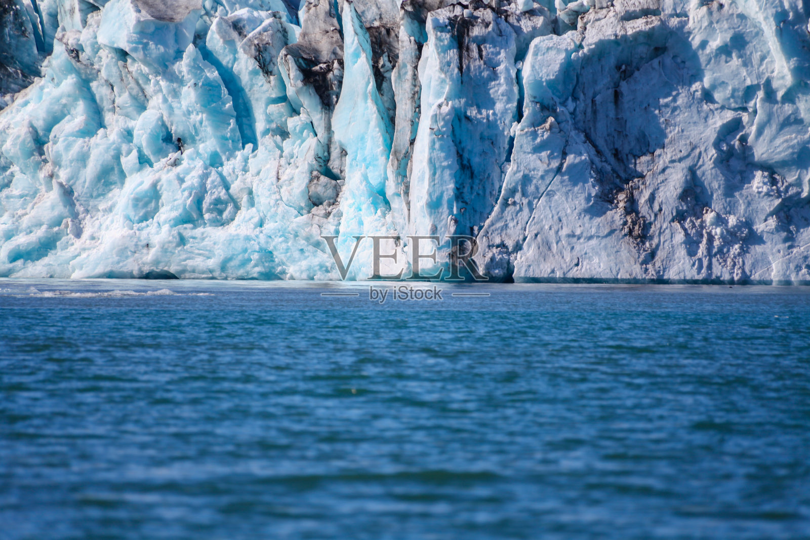 冰山漂浮。冰和火山灰。冰川湖。融化的冰。冰岛南部海岸。北极冰上的火山灰。冰河时代冰川裂缝正在快速融化。全球变暖。冰川的边缘照片摄影图片