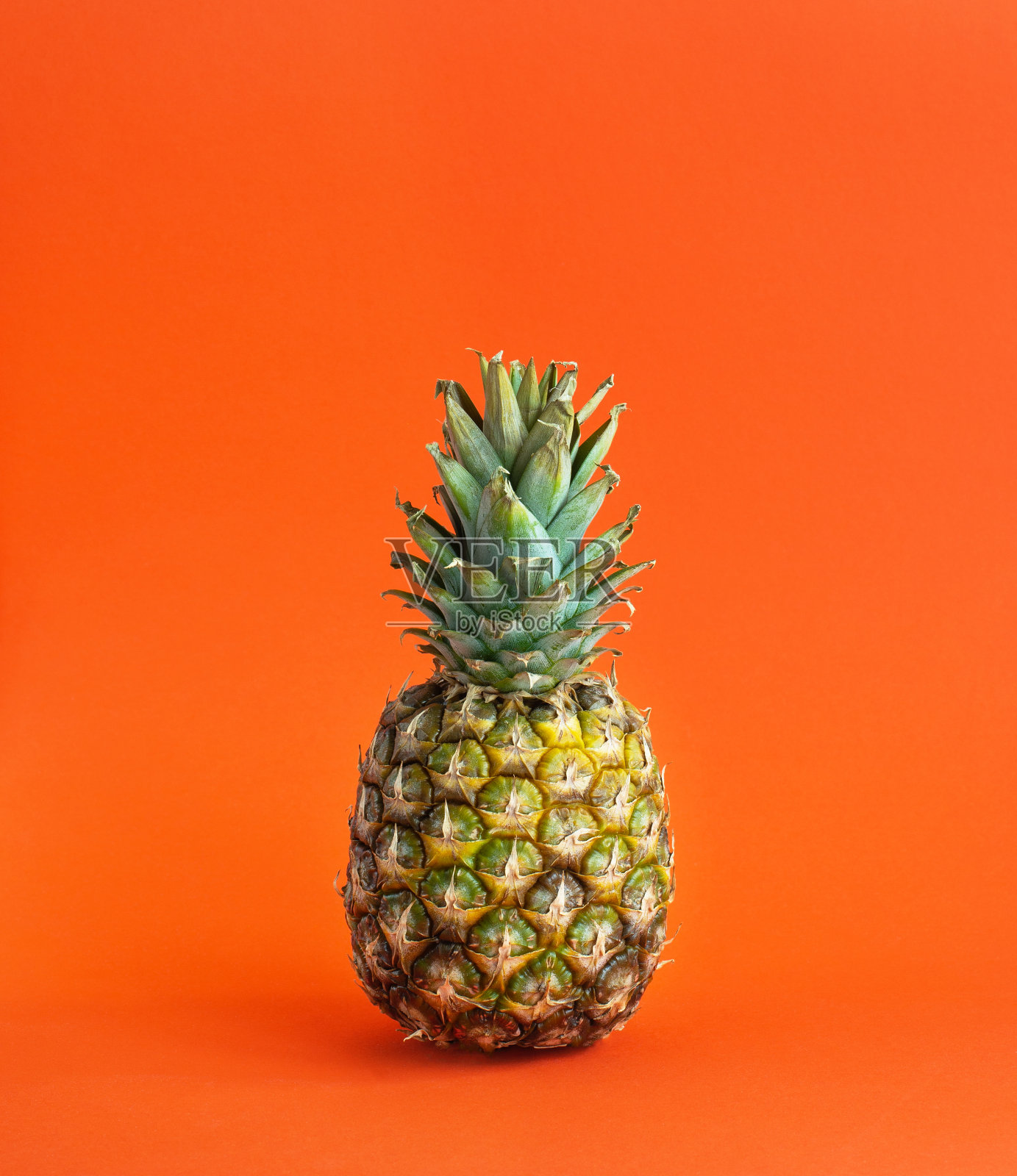 明亮的橙色背景上的菠萝照片摄影图片