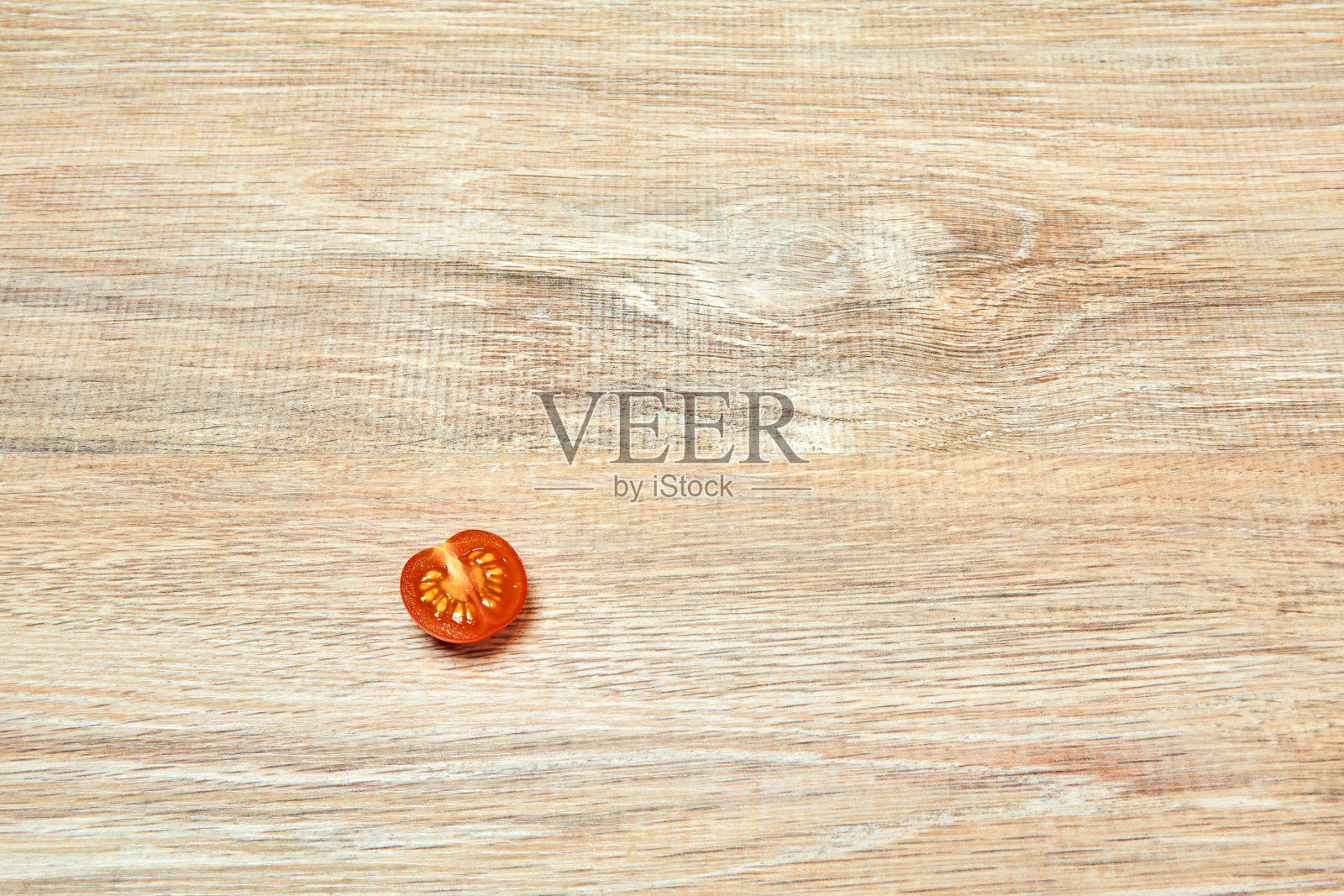 木桌面上放半个樱桃番茄照片摄影图片