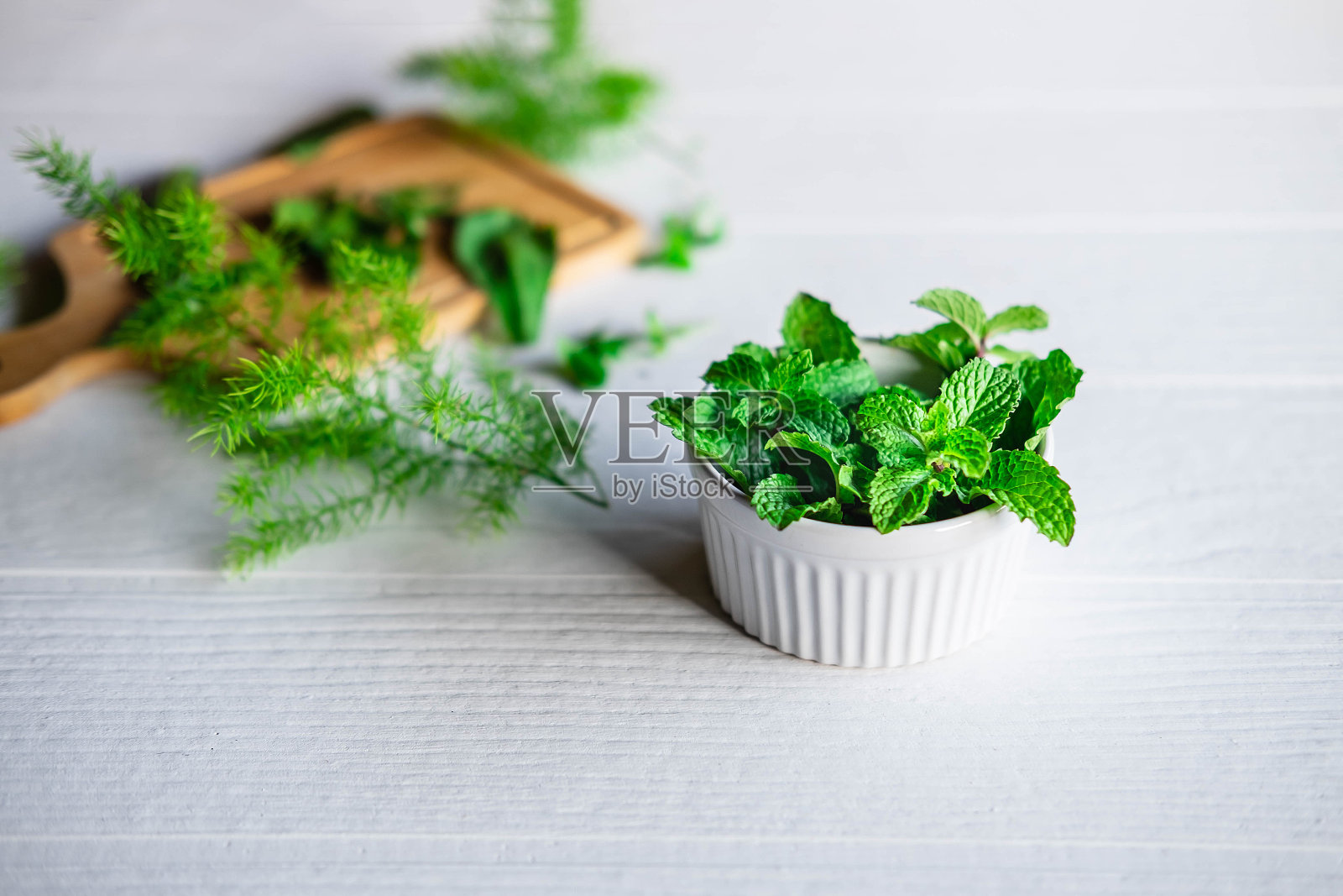 新鲜的薄荷香草放在一个白色的碗里照片摄影图片