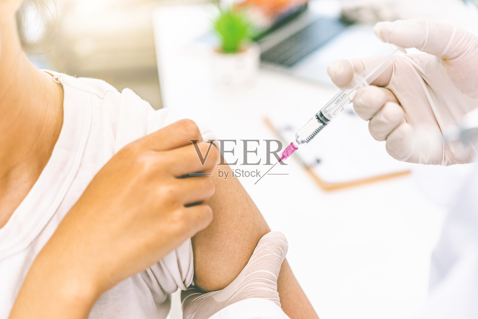 医生目前正在用手臂注射治疗病人。预防和治疗病毒的疫苗或药物。照片摄影图片