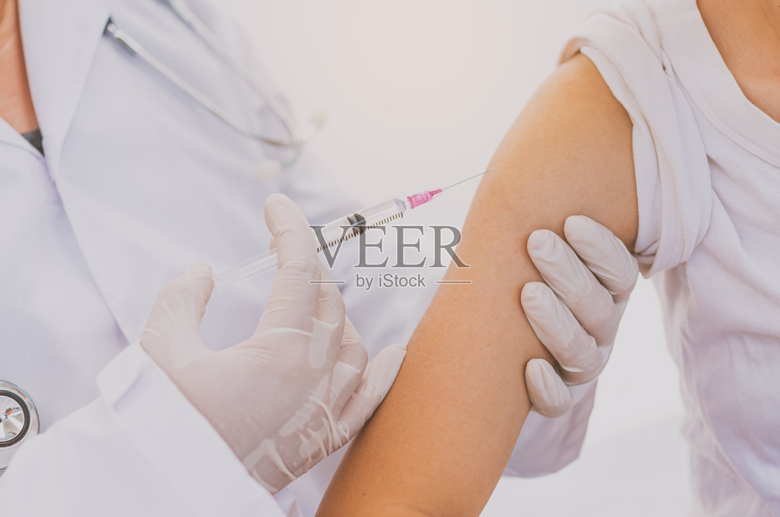 医生目前正在用手臂注射治疗病人。预防和治疗病毒的疫苗或药物。照片摄影图片