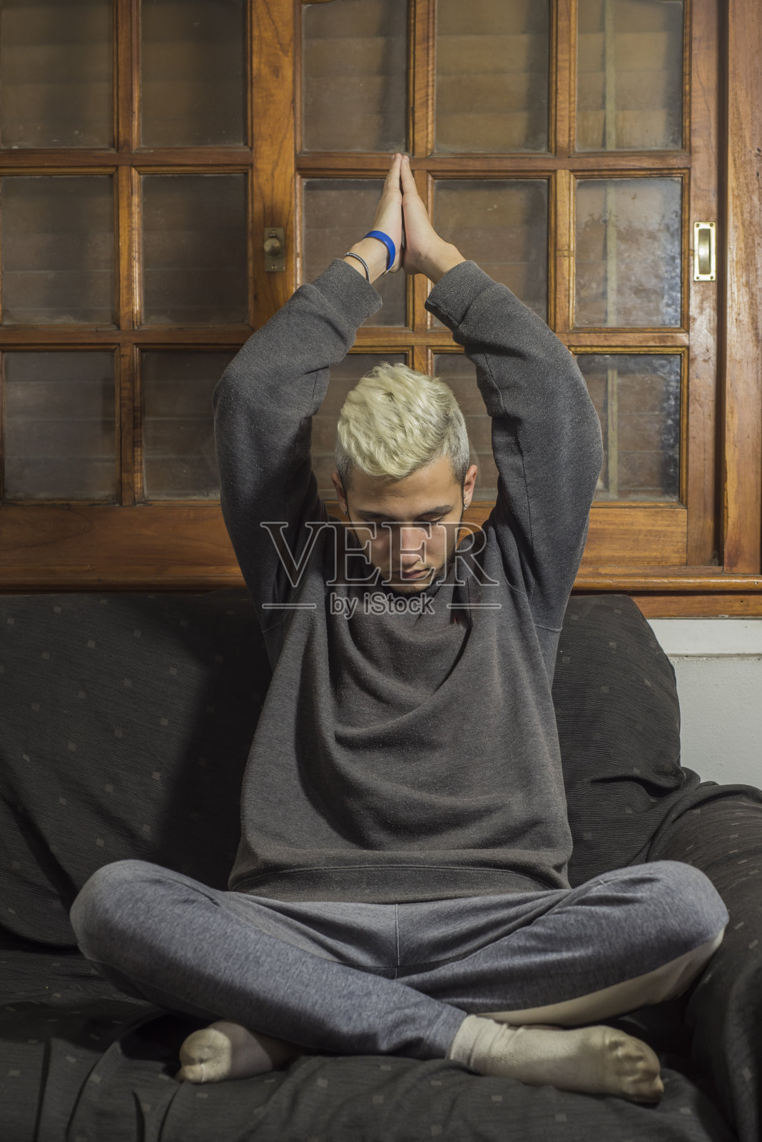 因冠状病毒感染而被隔离的青年男子通过在家冥想和放松加强心理健康照片摄影图片