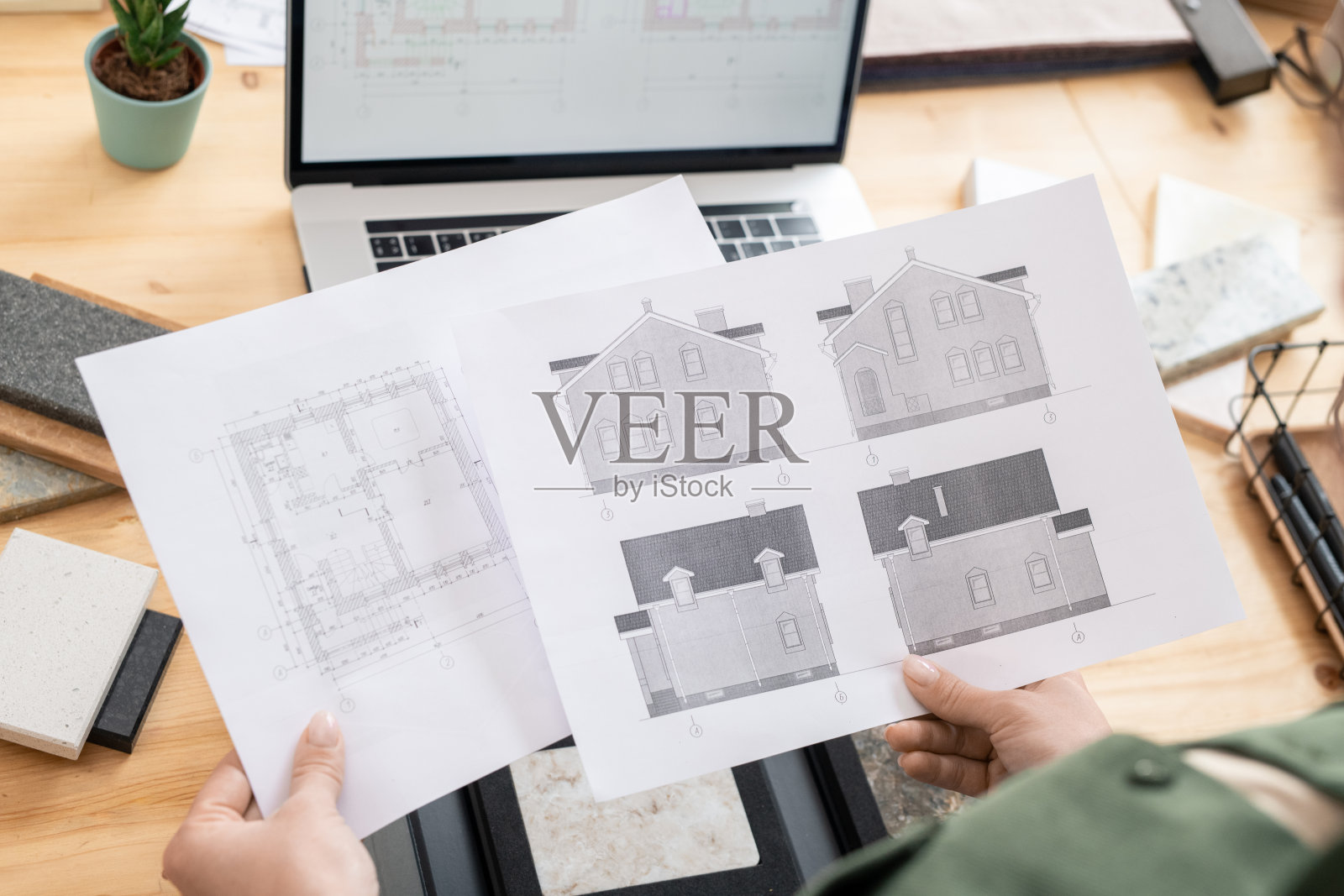 手握新房子的草图和平面图的女建筑师的文件照片摄影图片