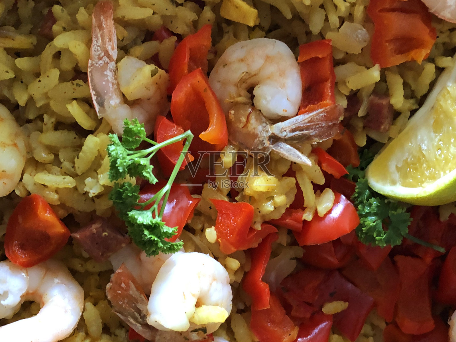 想象一下自制西班牙海鲜饭在平底锅中烹饪，配以短粒白米、藏红花、对虾/虾仁、鸡丁、海鲜贻贝、红辣椒，配以柠檬角和欧芹即可食用照片摄影图片