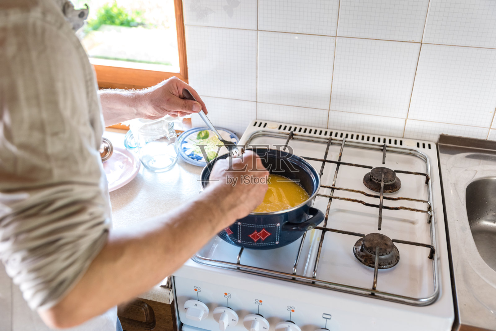 满足人在家庭厨房熔化黄油与制作酥油的准确性照片摄影图片