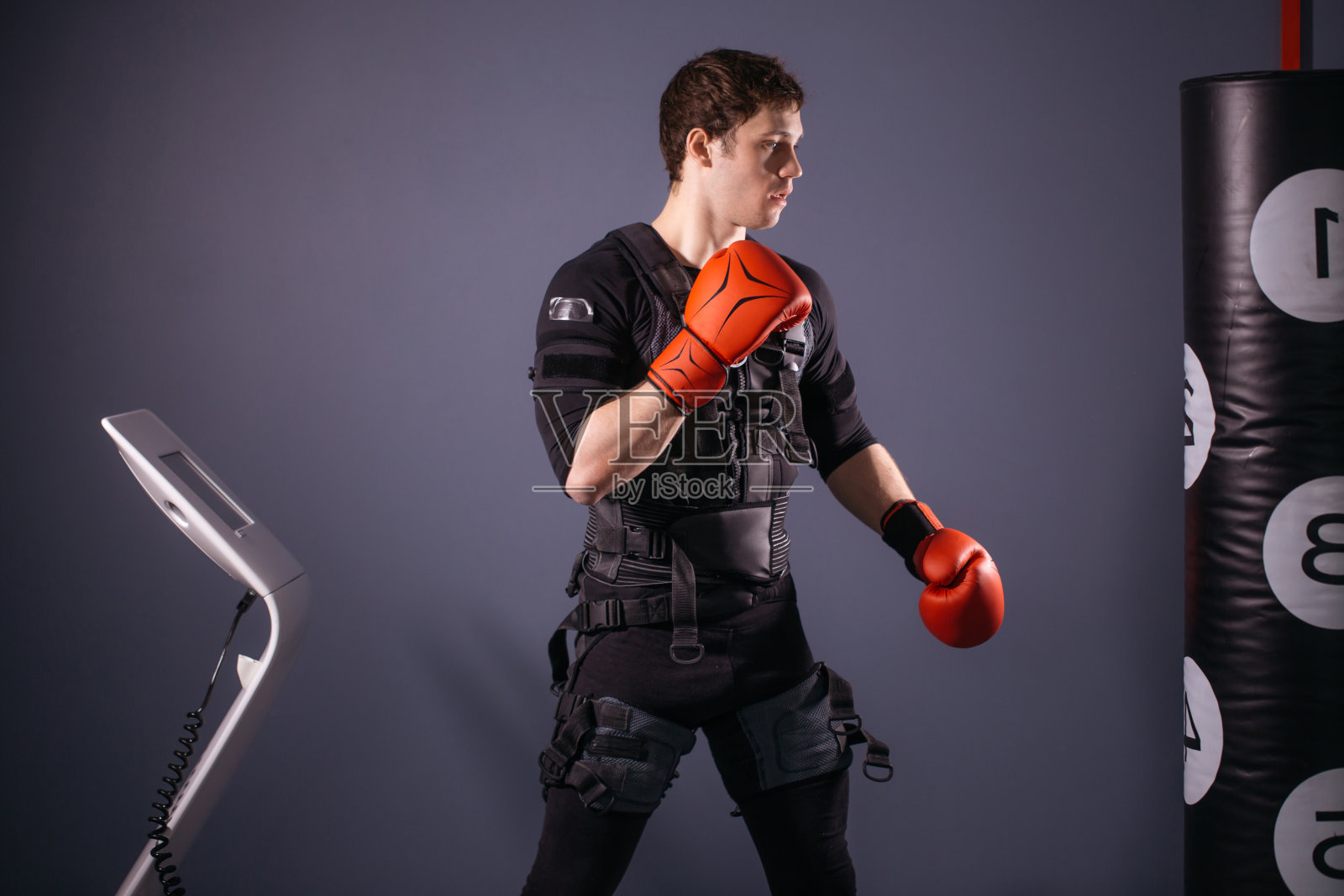 训练中戴拳击手套的男子。鲍克瑟在电刺激的套装照片摄影图片