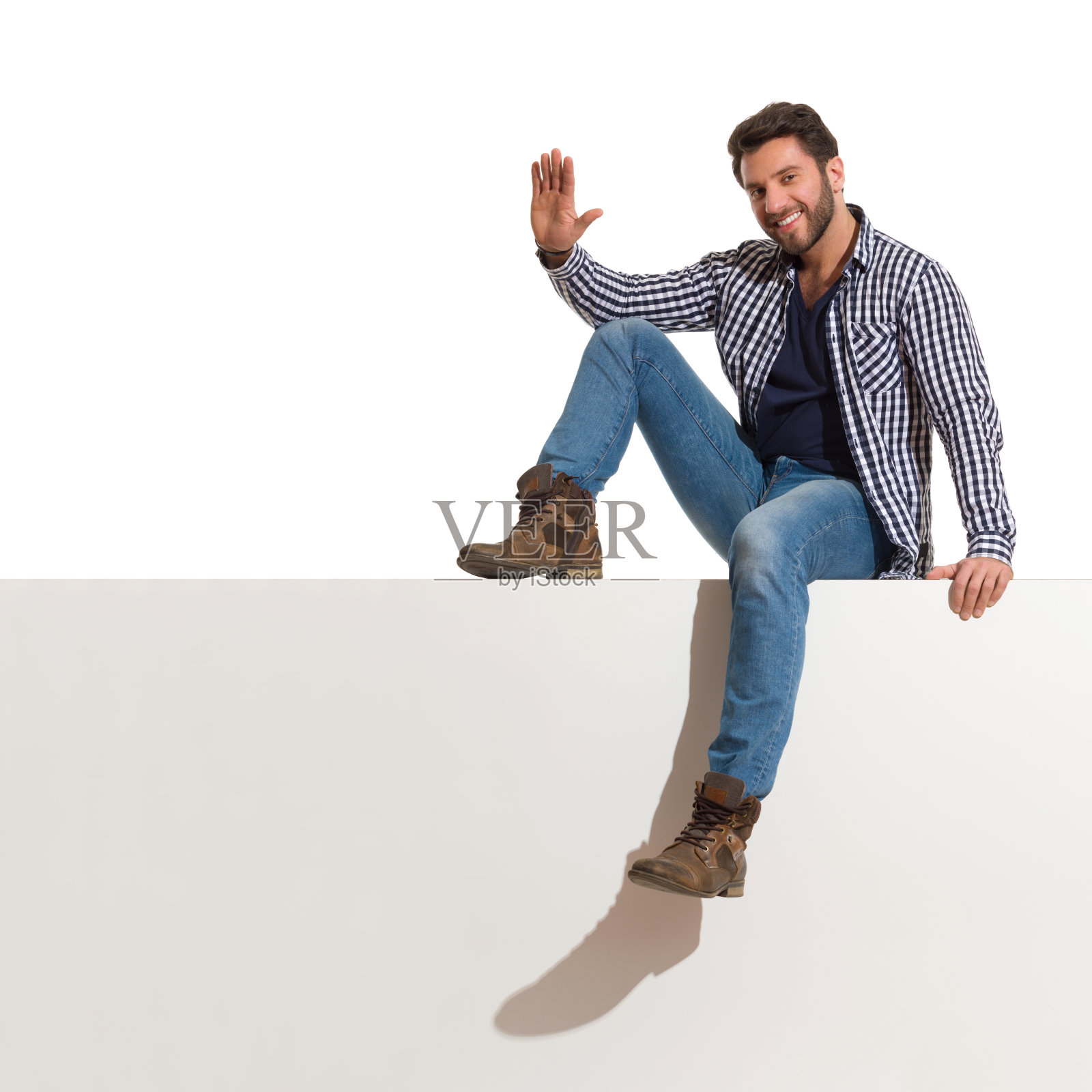 英俊的男人放松地坐在顶端，举起手照片摄影图片