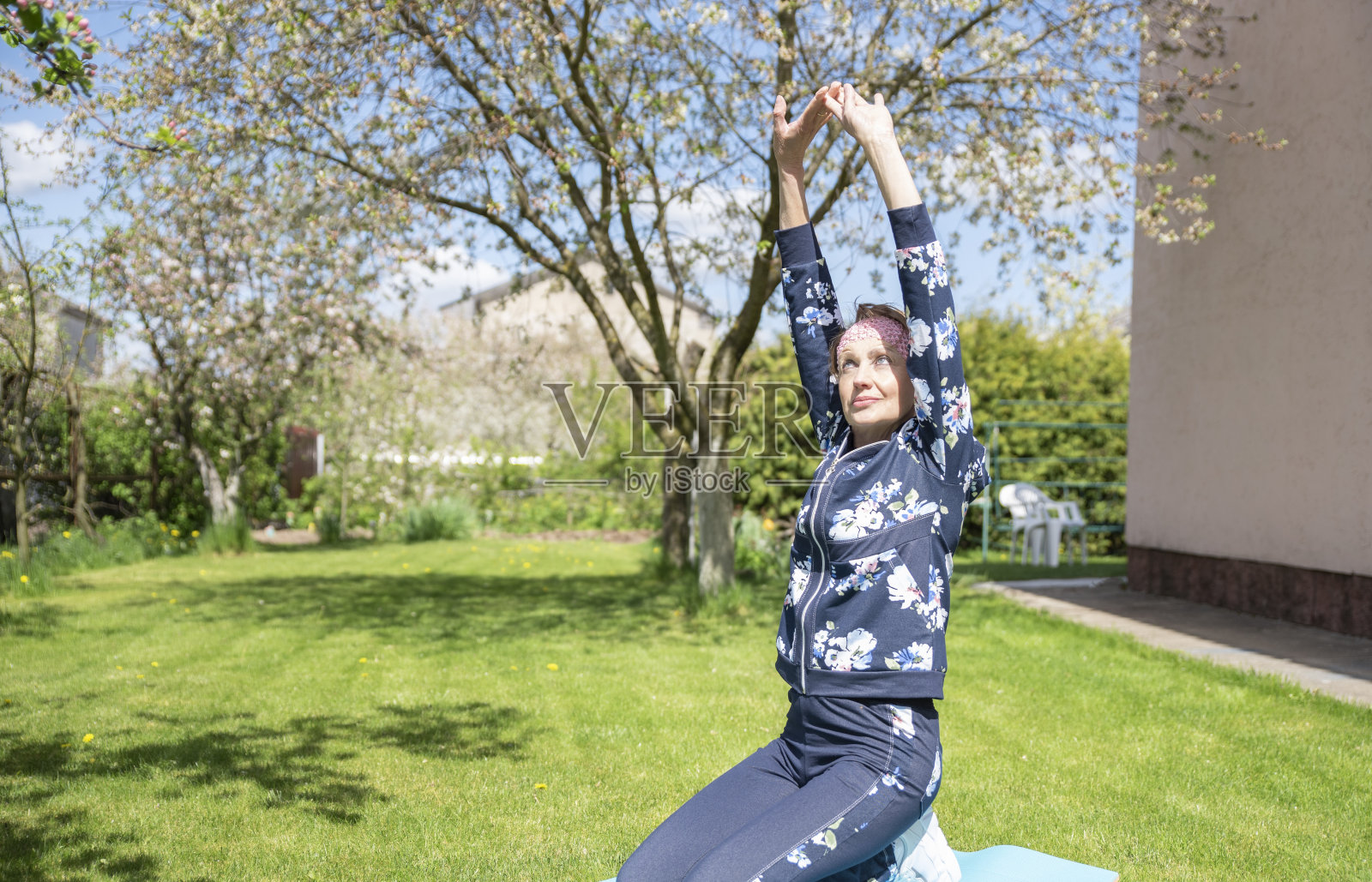 健身或瑜伽训练，老年妇女在家花园。照片摄影图片
