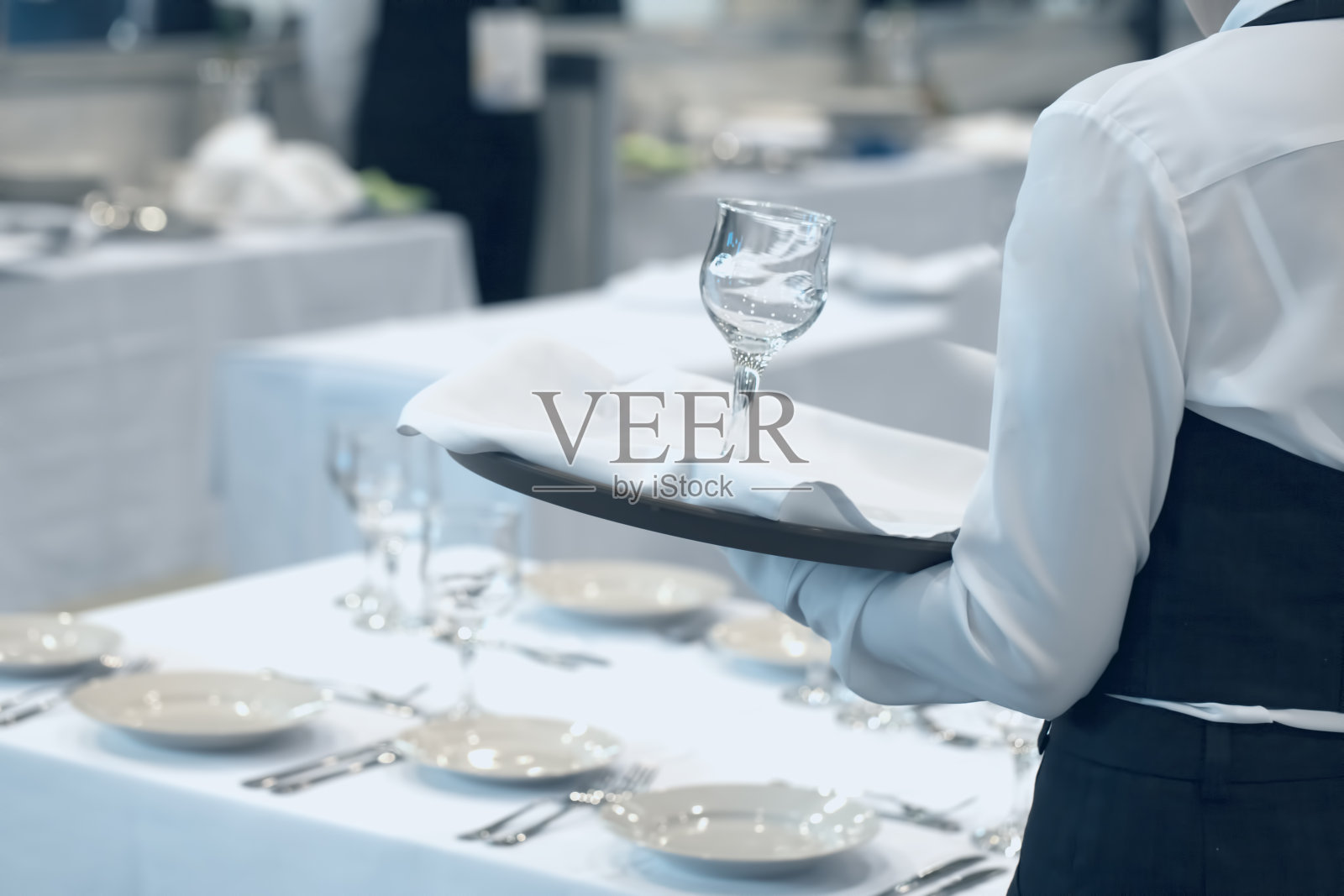 穿着制服的女服务员端上一套玻璃杯照片摄影图片