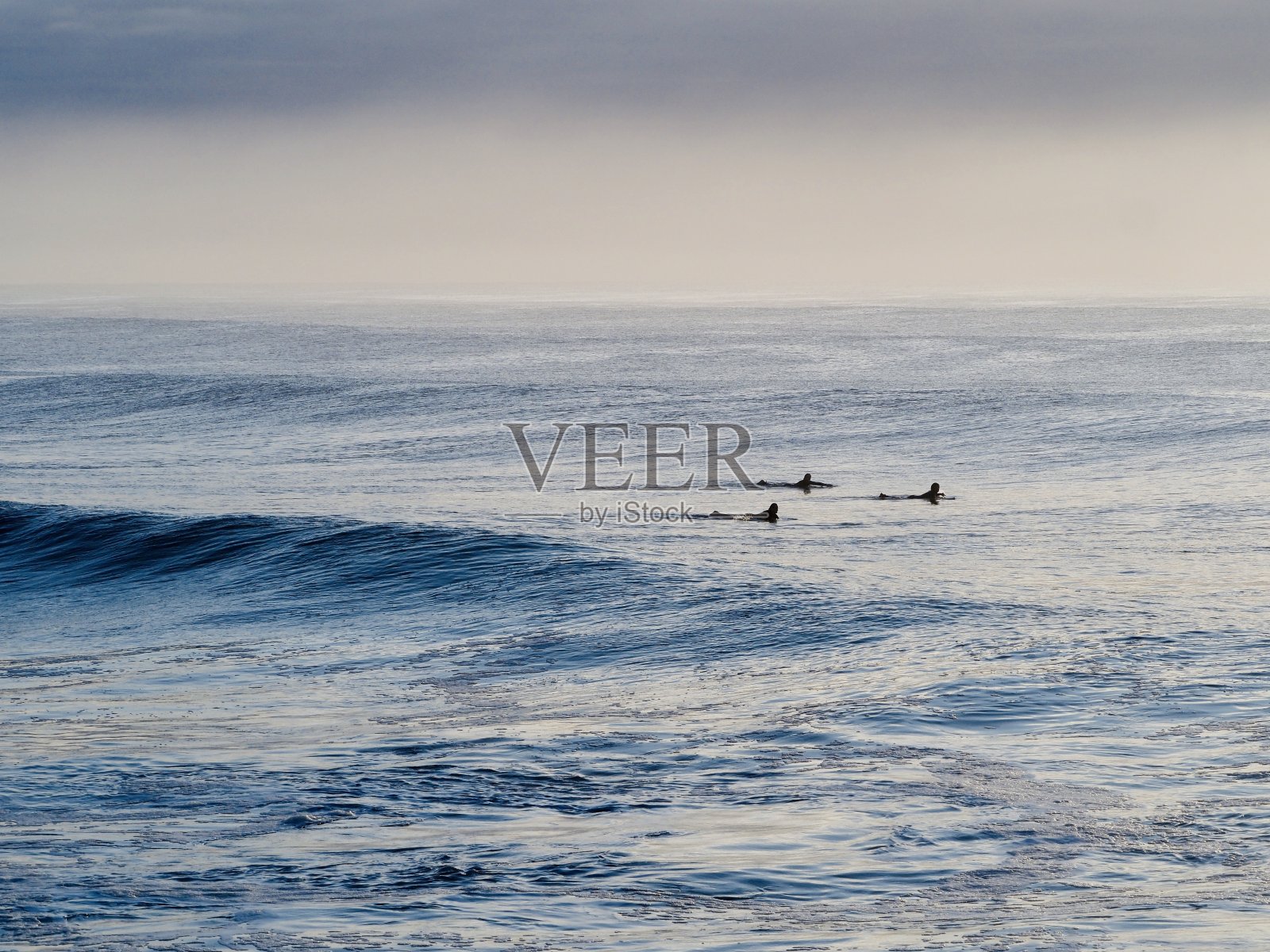 三个冲浪者在等待海浪照片摄影图片