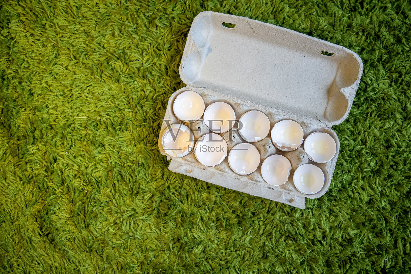 把破碎的空蛋壳放在人造草上的盒子里。俯视图，特写，拷贝空间照片摄影图片