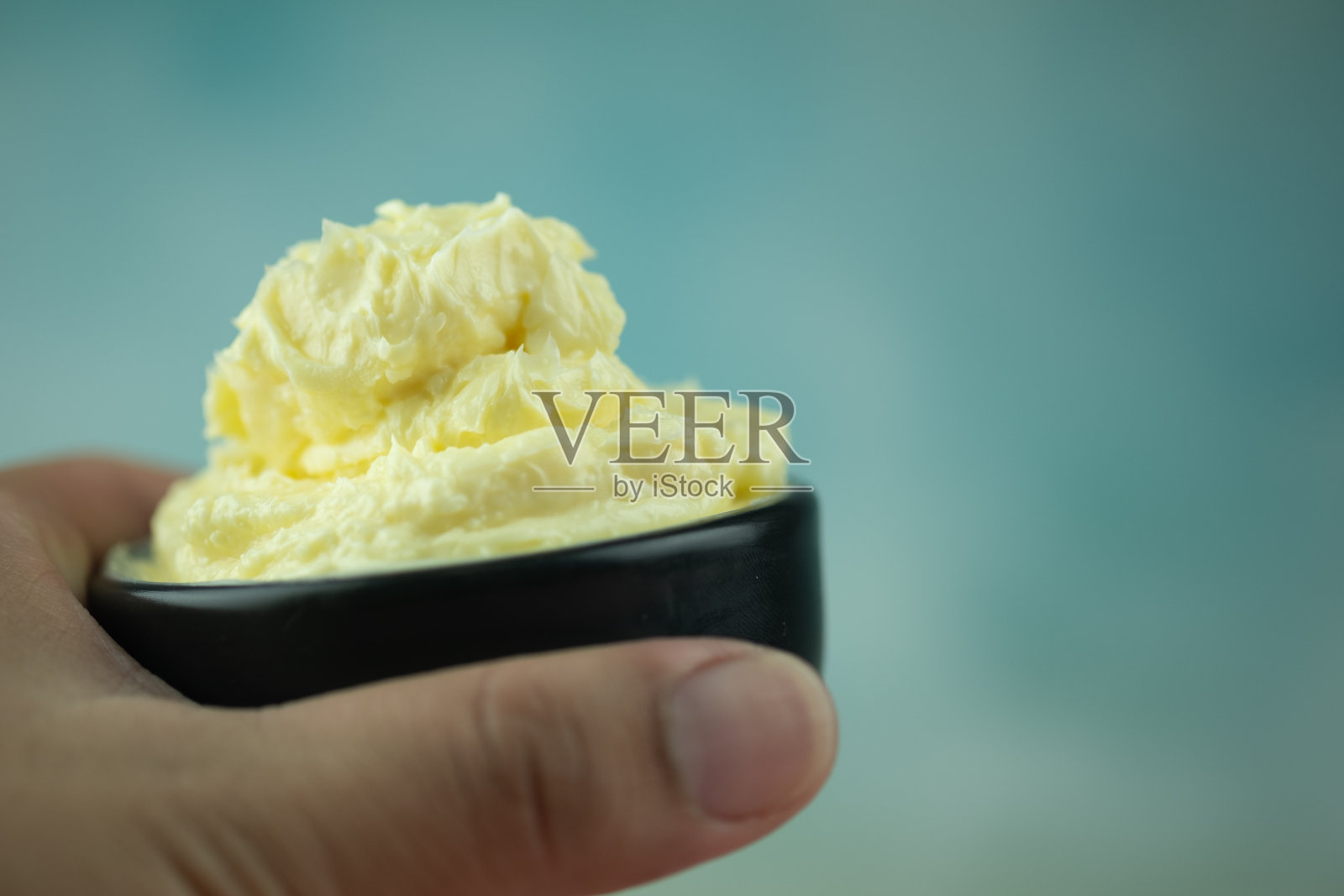 软黄油在黑碗准备烹饪。近距离照片摄影图片