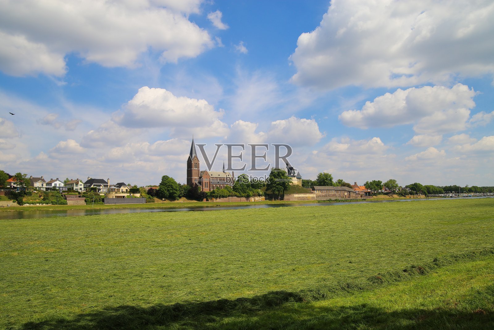 从比塞尔看到绿色的农田和马斯河与船在中世纪教堂和城堡凯塞尔-荷兰照片摄影图片