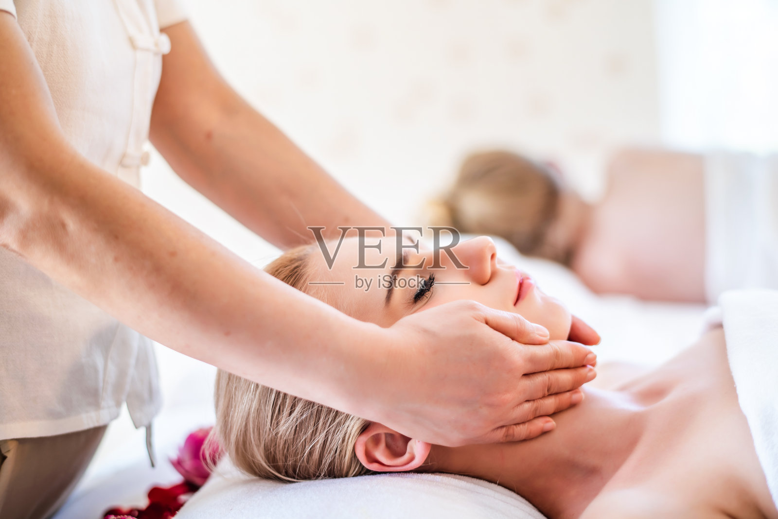 美丽年轻有吸引力的白种女人有头部按摩泰国按摩师在水疗沙龙。美体护理生活理念照片摄影图片