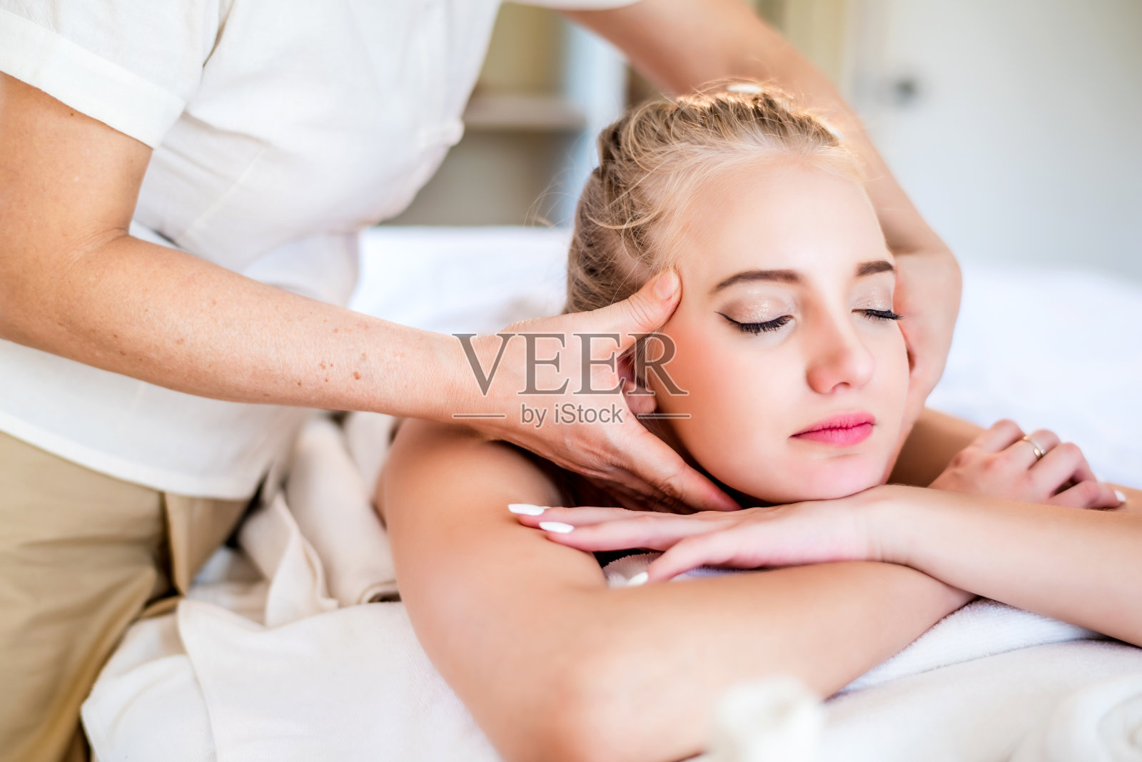 美丽年轻有吸引力的白种女人有头部按摩泰国按摩师在水疗沙龙。美体护理生活理念照片摄影图片