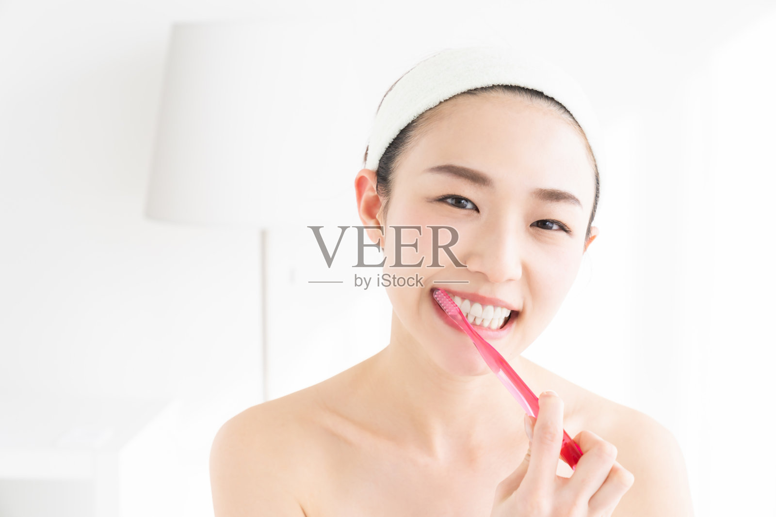 亚洲女性用健康的牙齿拿着牙刷，进行口腔护理照片摄影图片