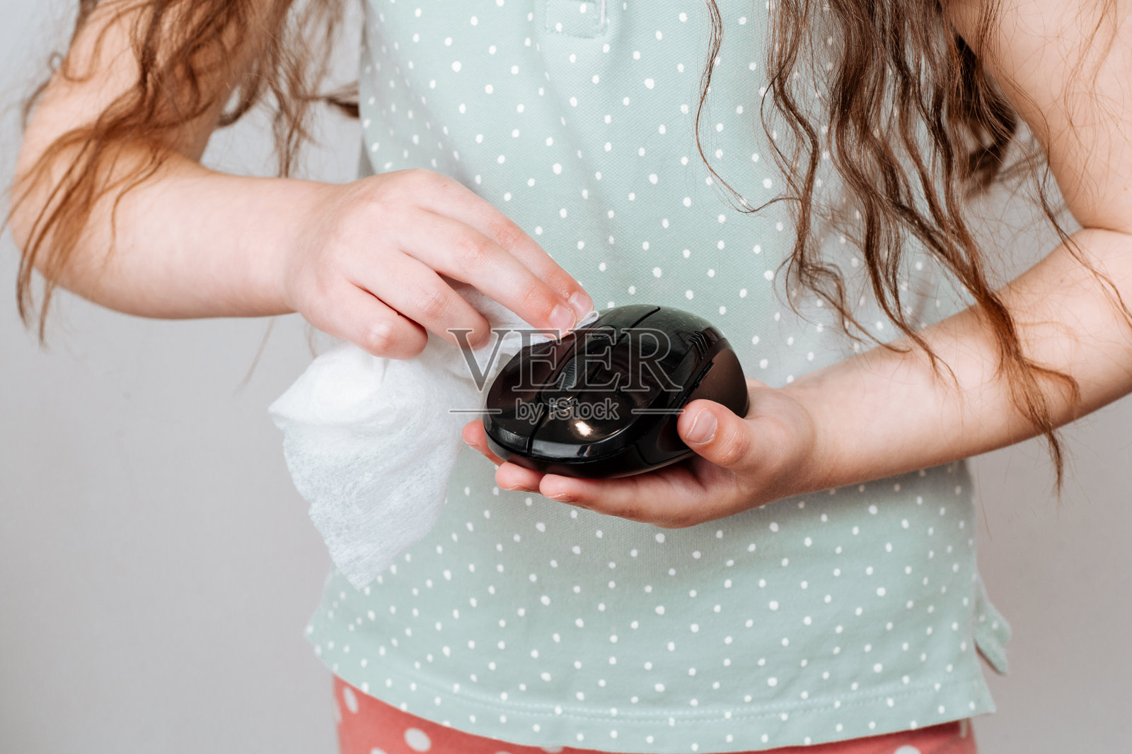 一个女孩用消毒液擦拭电脑鼠标照片摄影图片