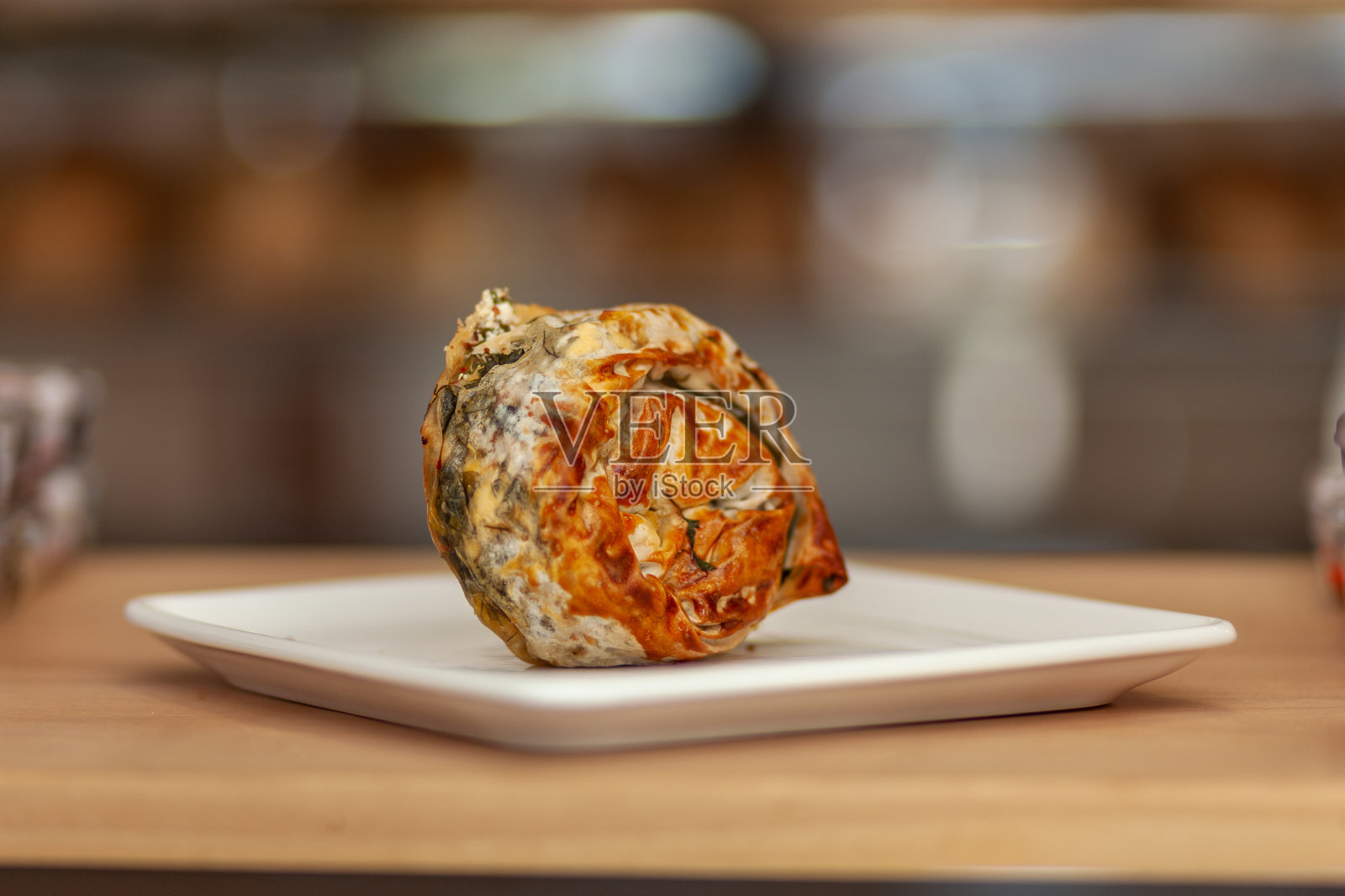 在木桌上;菠菜布丁/ ispanakli gul boregi照片摄影图片