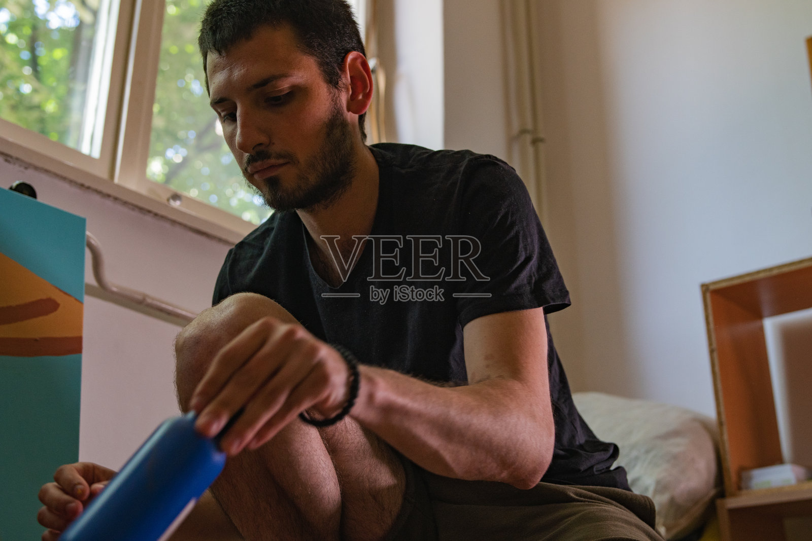 年轻的艺术家坐在地板上照片摄影图片