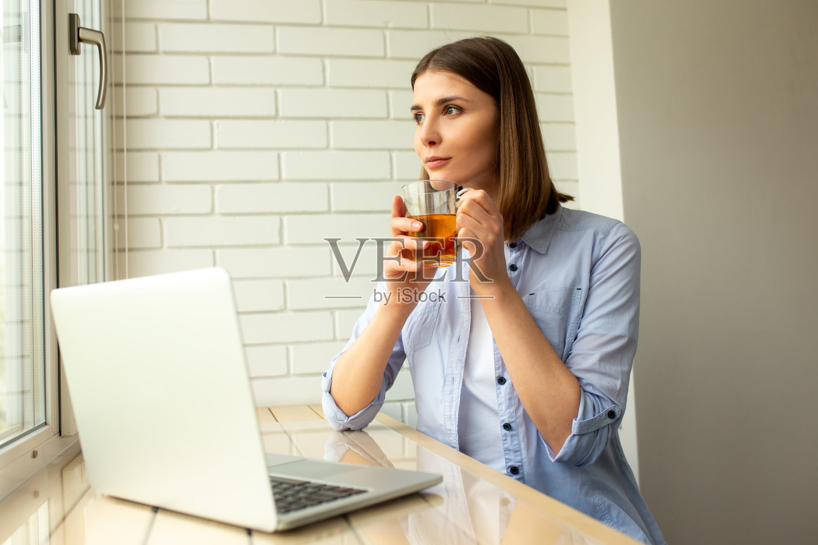 漂亮的女人坐在桌边喝茶照片摄影图片