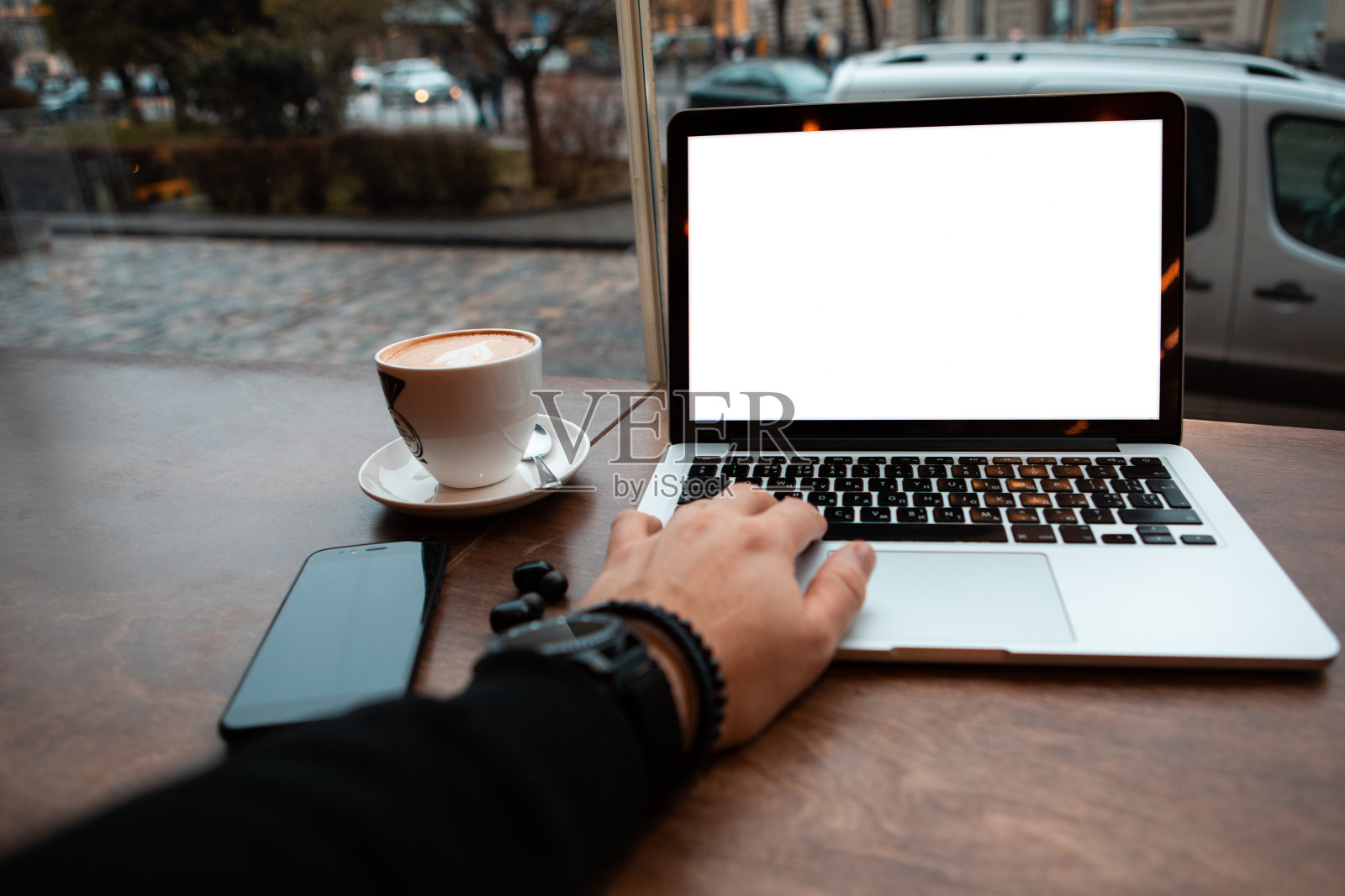 白色屏幕的笔记本电脑放在靠近窗户的咖啡桌上照片摄影图片