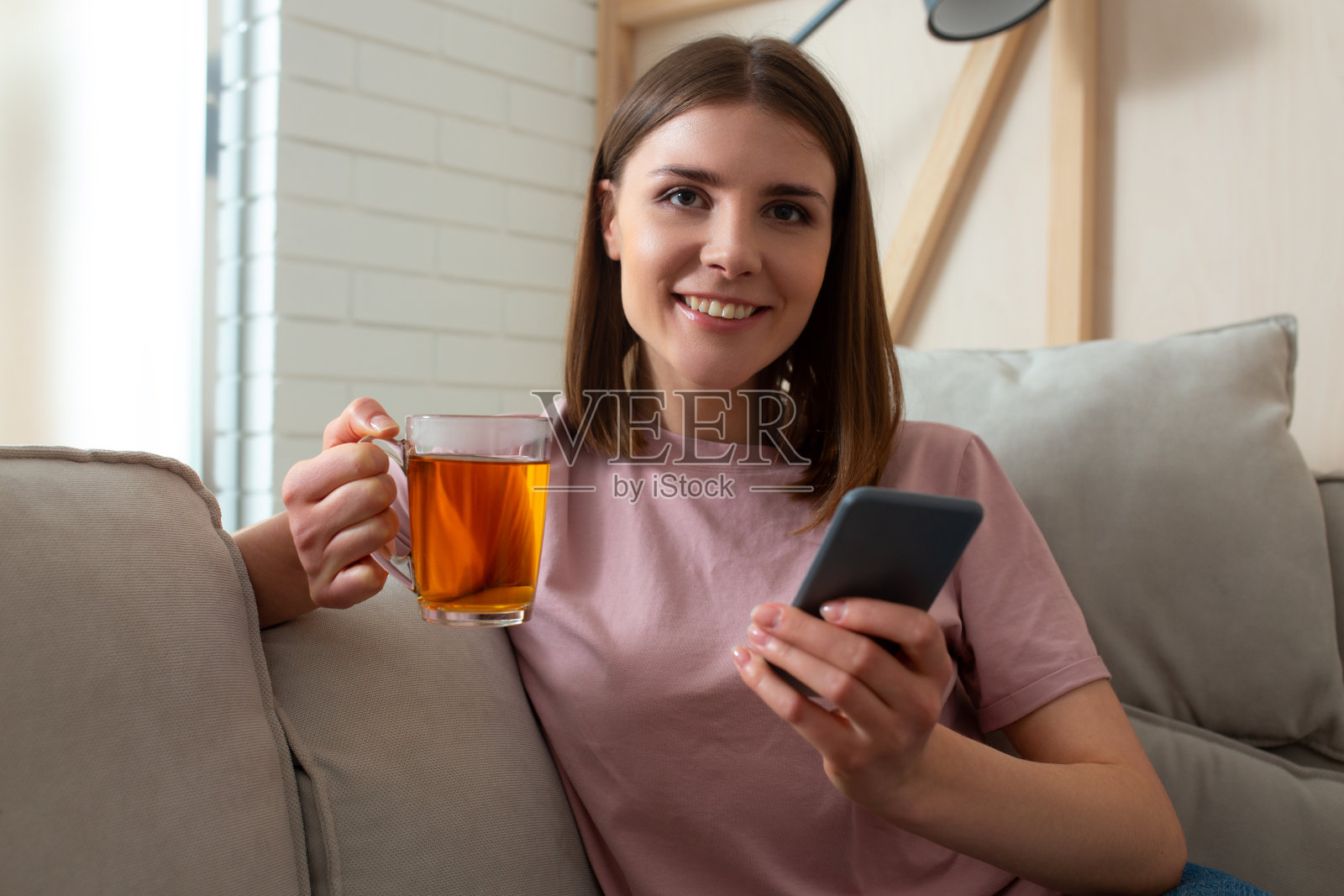 快乐的美女拿着她的智能手机照片摄影图片