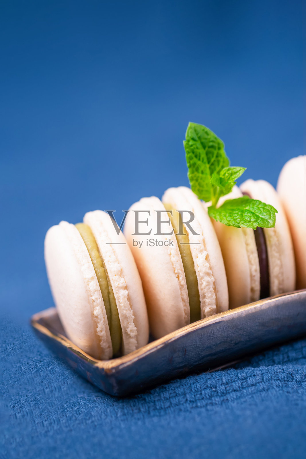 自制香草马卡龙或薄荷叶马卡龙经典的蓝色背景照片摄影图片