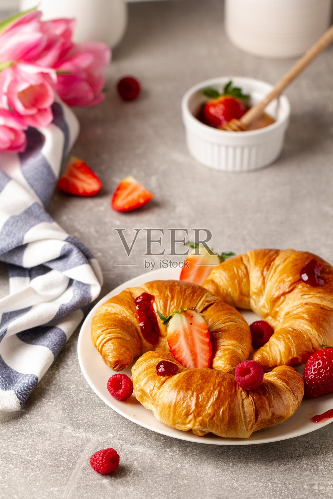 桌上有美味的黄油牛角面包和浆果。早餐照片摄影图片