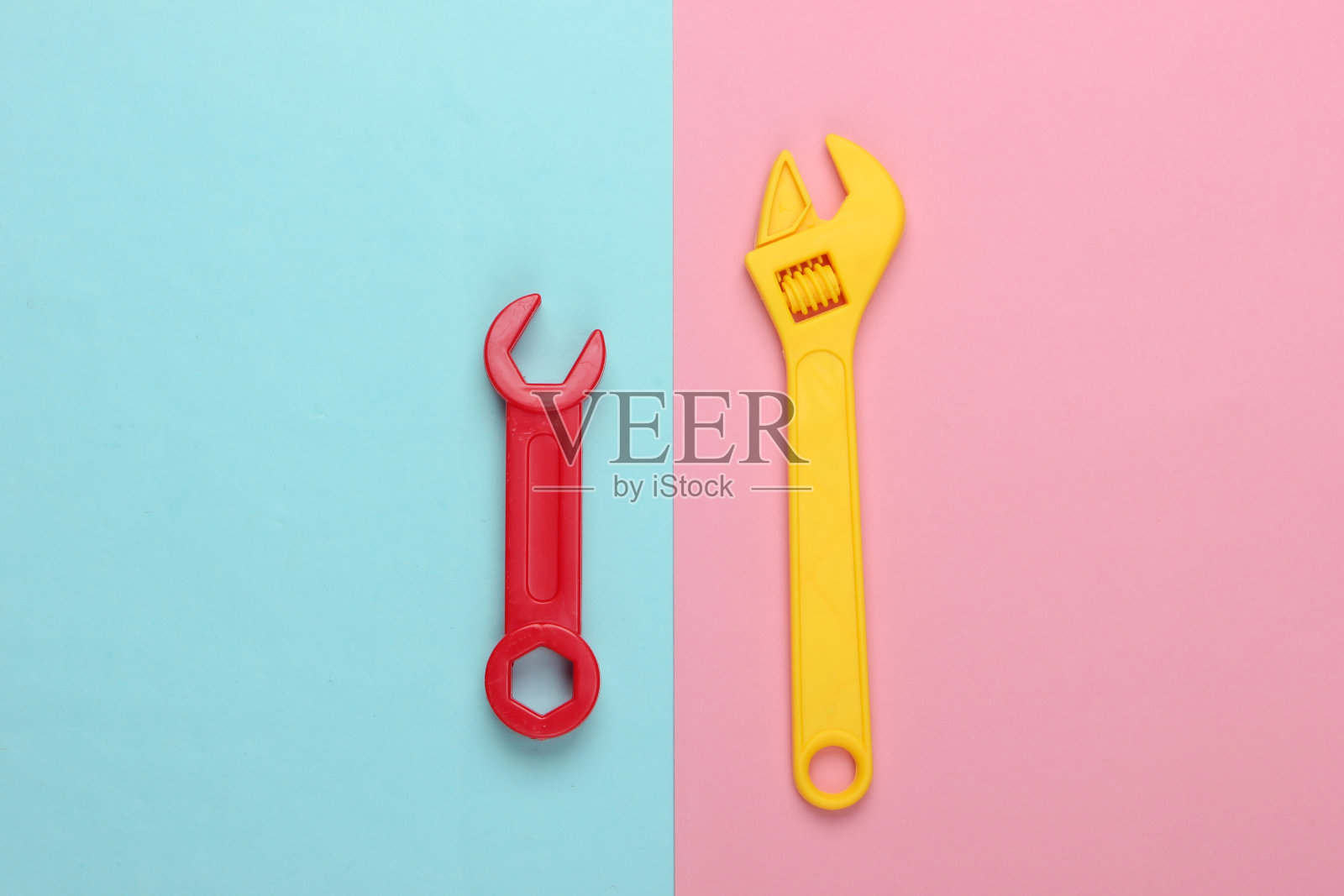 粉蓝色背景上的玩具扳手。俯视图照片摄影图片