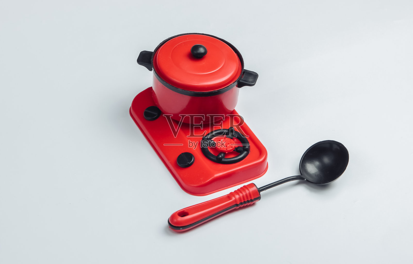 玩具炉与锅和勺在一个白色的背景照片摄影图片