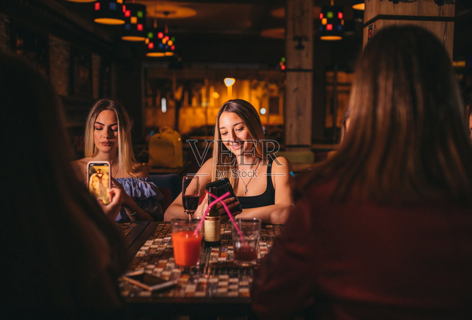 快乐的年轻女子在咖啡馆用手机照片摄影图片