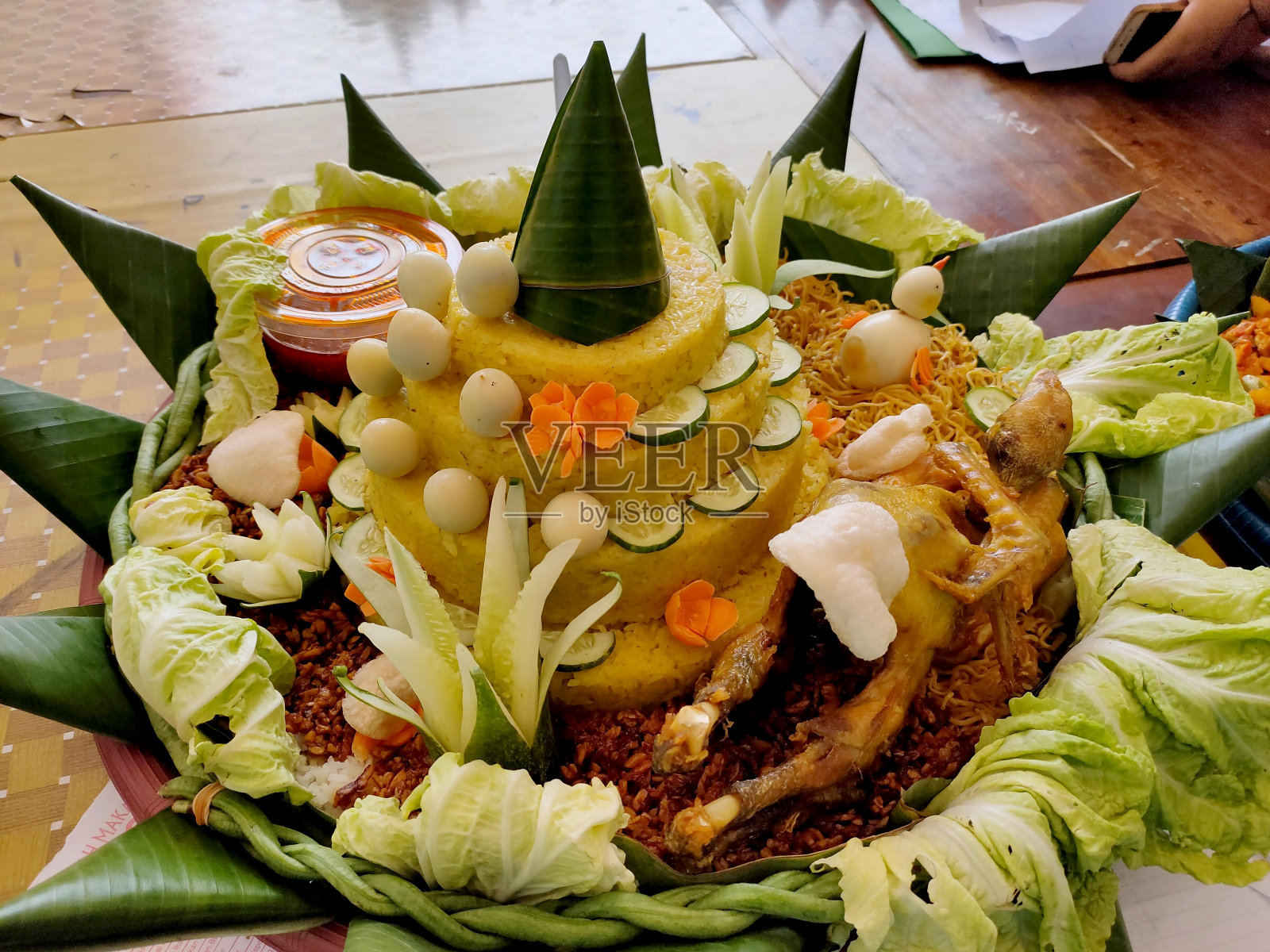 米饭Tumpeng。圆锥形黄米。一种带有配菜的印尼节日饭。印尼食品照片摄影图片