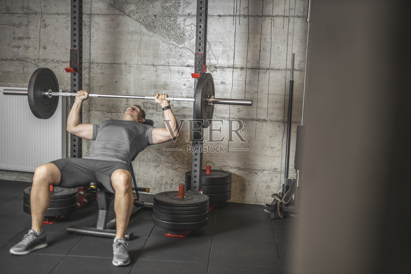 做卧推的运动员，在专业体育馆训练的运动员，为二头肌、胸肌和背部肌肉举重照片摄影图片