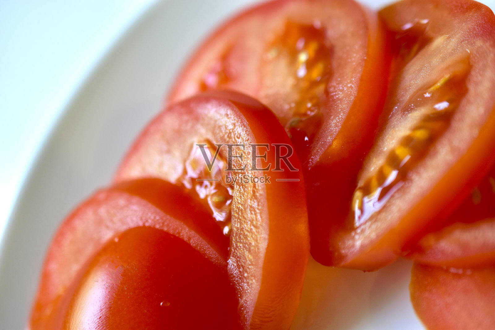 熟透多汁的西红柿切片放在白色盘子里照片摄影图片